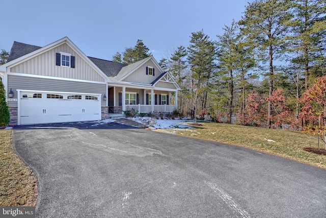 craftsman-style home featuring a porch, a garage, and a front yard