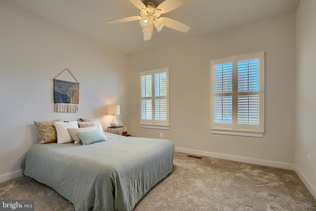 bedroom with multiple windows, light colored carpet, and ceiling fan