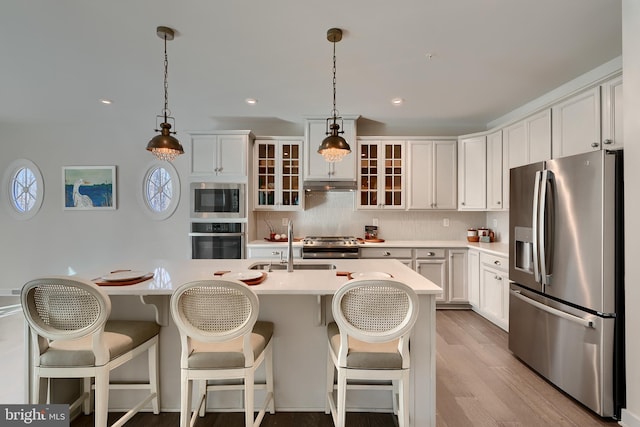 kitchen featuring decorative light fixtures, built in microwave, white cabinets, wall oven, and stainless steel refrigerator with ice dispenser