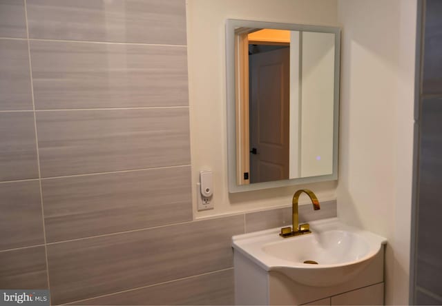 bathroom with vanity and tile walls