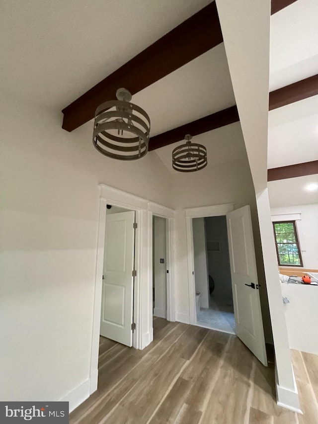 interior space with vaulted ceiling with beams and hardwood / wood-style flooring