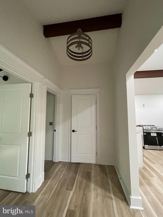 hall with beamed ceiling and light hardwood / wood-style flooring