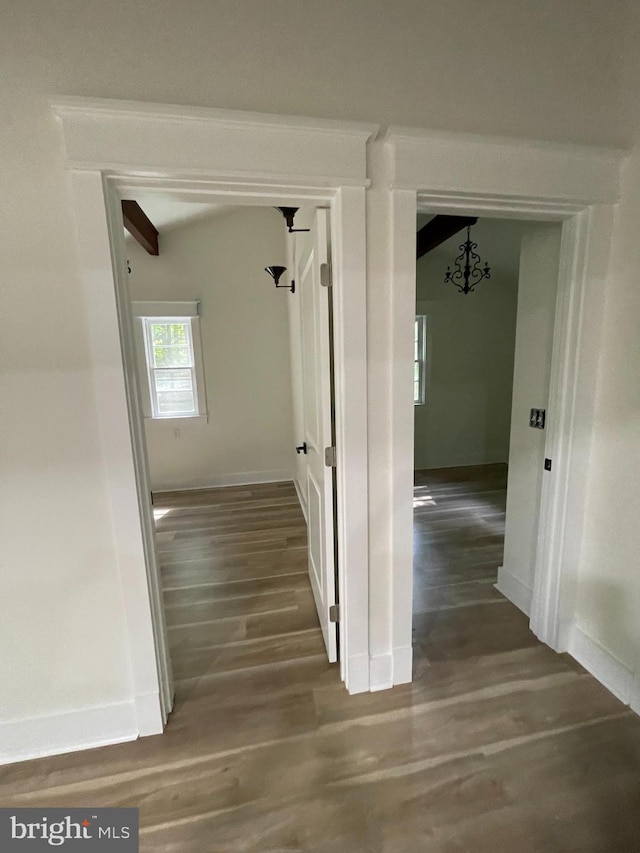 corridor with wood-type flooring and beam ceiling