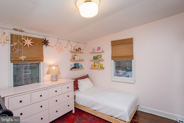 bedroom with dark hardwood / wood-style floors