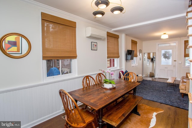 dining space with a wall mounted AC, crown molding, and dark wood-type flooring