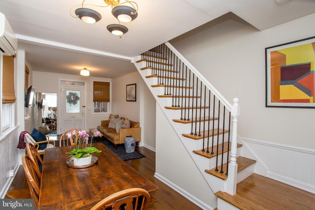 dining space with a wall mounted AC and dark hardwood / wood-style flooring