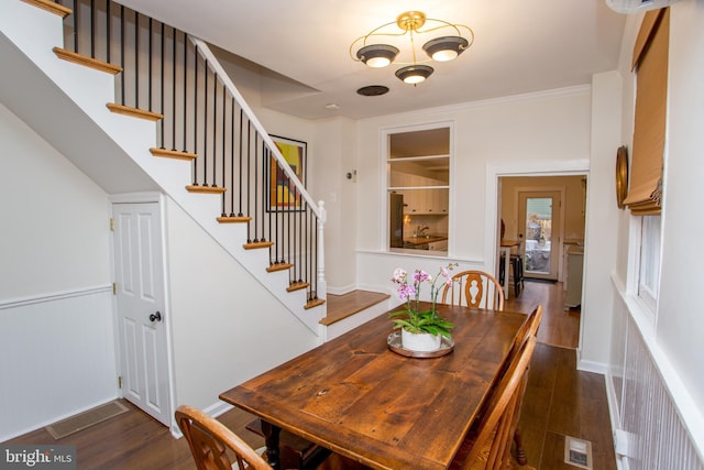 dining room with dark hardwood / wood-style flooring and crown molding