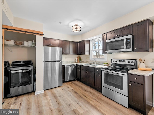 kitchen featuring stainless steel appliances, sink, dark brown cabinetry, and light hardwood / wood-style floors