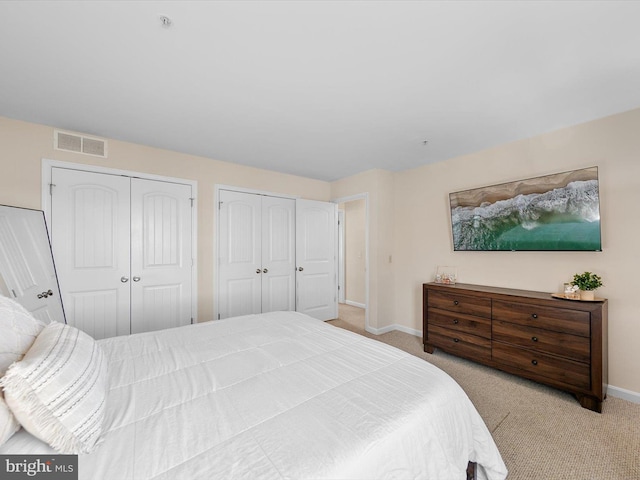 carpeted bedroom with multiple closets