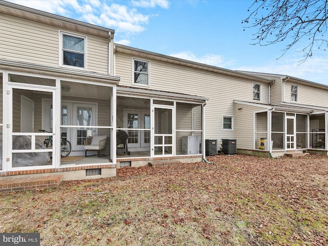 rear view of property featuring a sunroom and central air condition unit