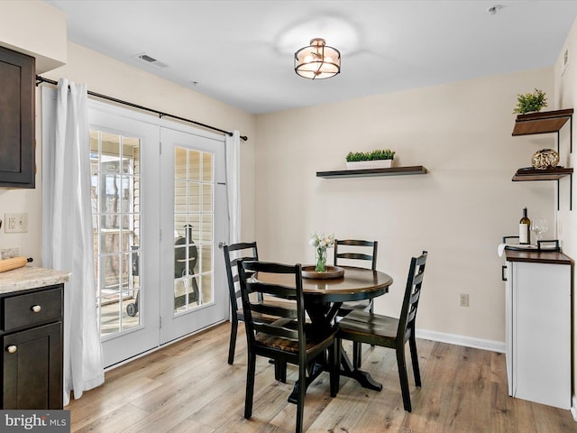 dining space featuring french doors and light wood-type flooring