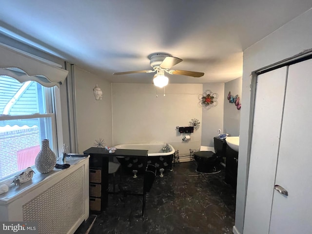 bathroom featuring toilet, radiator, a baseboard heating unit, a tub to relax in, and ceiling fan