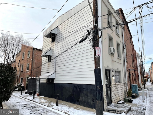 snow covered property with cooling unit