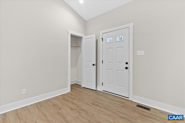 foyer entrance featuring light wood-type flooring and vaulted ceiling