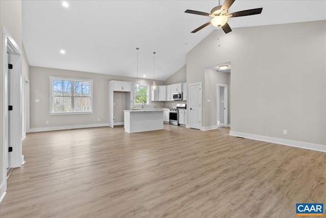 unfurnished living room featuring light wood-type flooring, ceiling fan, and high vaulted ceiling