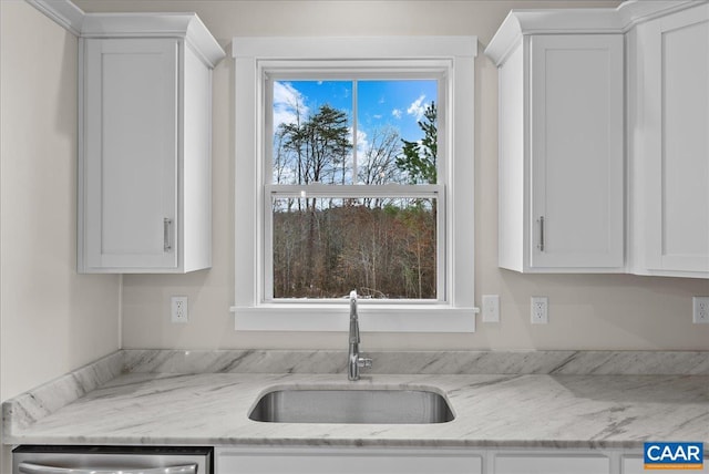 kitchen with light stone counters, sink, a wealth of natural light, and white cabinets