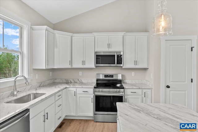 kitchen with sink, vaulted ceiling, white cabinets, and appliances with stainless steel finishes