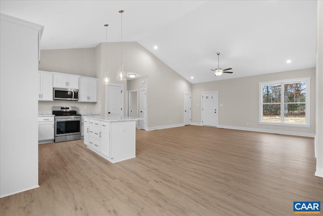 kitchen with a center island, white cabinetry, hanging light fixtures, light wood-type flooring, and stainless steel appliances