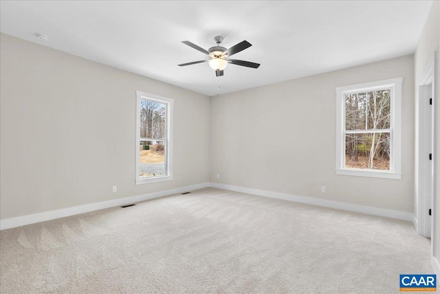 carpeted spare room with ceiling fan and a wealth of natural light