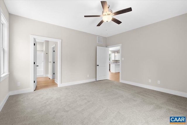 unfurnished bedroom with ceiling fan and light colored carpet