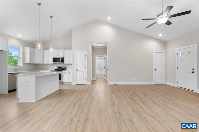 kitchen featuring white cabinets, stainless steel appliances, a center island, and pendant lighting