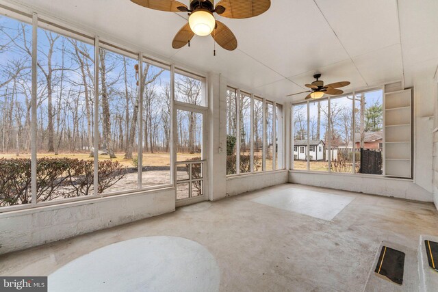 unfurnished sunroom featuring ceiling fan and a healthy amount of sunlight