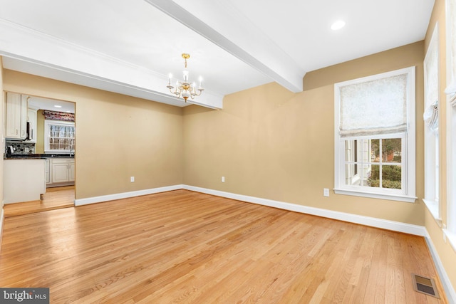 interior space with a notable chandelier, a wealth of natural light, light hardwood / wood-style floors, and beamed ceiling