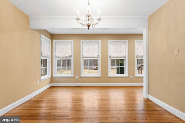 unfurnished dining area with ornamental molding, hardwood / wood-style floors, and an inviting chandelier