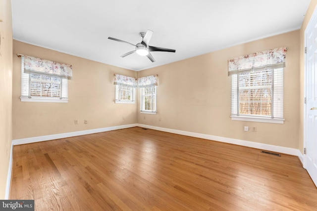 empty room with hardwood / wood-style floors and ceiling fan