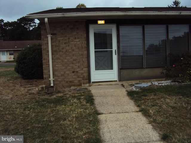 property entrance with a lawn