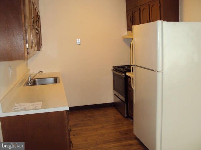 kitchen with stainless steel electric range, white fridge, dark hardwood / wood-style flooring, and sink