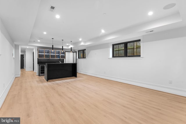 3819 NW Albemarle St NW, Washington, DC 20016 - unfurnished living room with a tray ceiling, recessed lighting, beverage cooler, and light wood-style flooring
