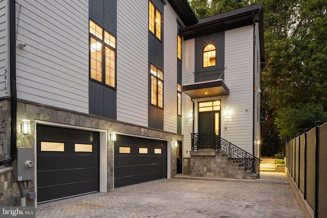 3819 NW Albemarle St NW, Washington, DC 20016 - view of front facade featuring stone siding, an attached garage, and decorative driveway
