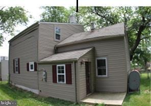 back of property with a lawn and a patio