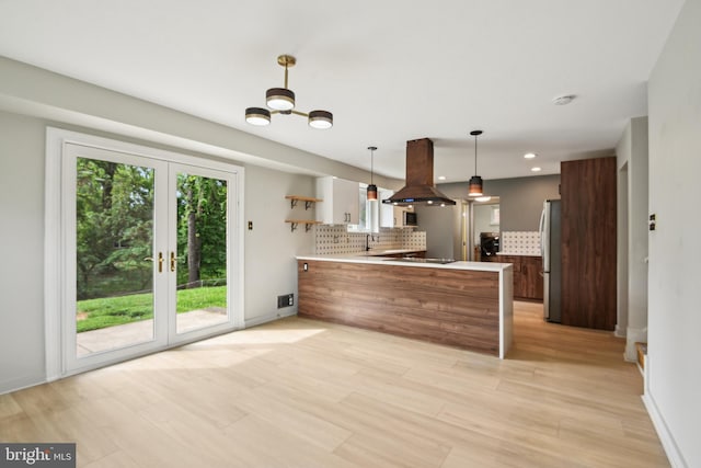 906 N Belgrade Rd, Silver Spring, MD 20902 - kitchen featuring island exhaust hood, a peninsula, freestanding refrigerator, tasteful backsplash, and a sink