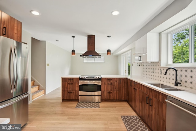 906 N Belgrade Rd, Silver Spring, MD 20902 - kitchen with appliances with stainless steel finishes, island range hood, a sink, light wood finished floors, and a peninsula