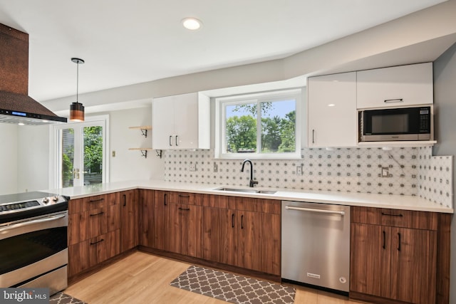 906 N Belgrade Rd, Silver Spring, MD 20902 - kitchen featuring appliances with stainless steel finishes, wall chimney range hood, a sink, white cabinets, and light wood-style floors