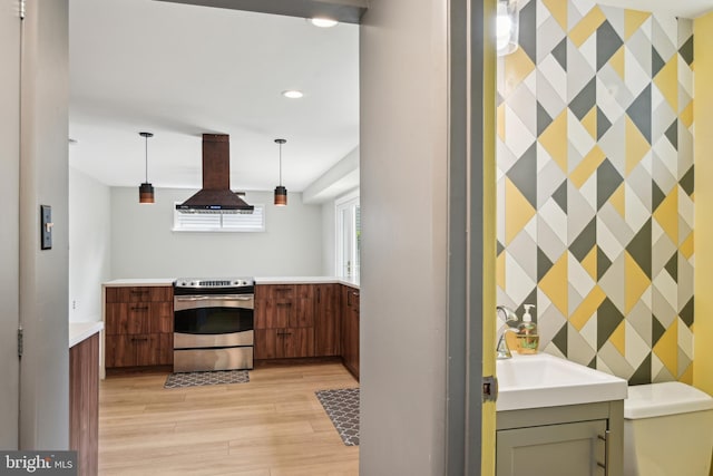 906 N Belgrade Rd, Silver Spring, MD 20902 - kitchen featuring stainless steel range with electric stovetop, an accent wall, island exhaust hood, light wood-style floors, and wallpapered walls