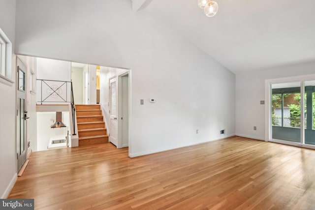 906 N Belgrade Rd, Silver Spring, MD 20902 - unfurnished living room with high vaulted ceiling, light wood-style flooring, stairway, and baseboards