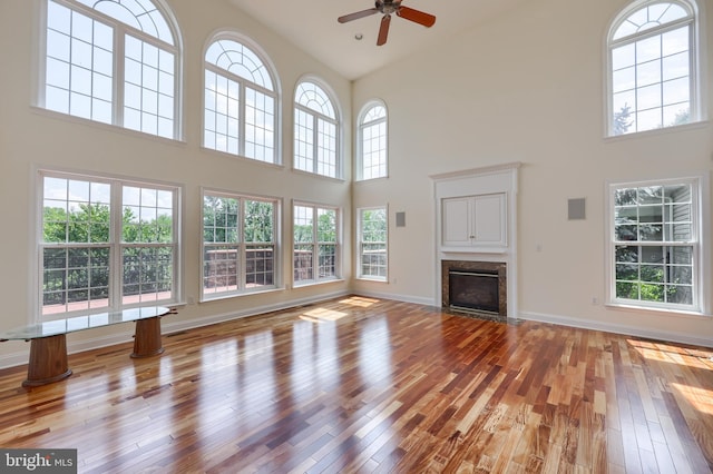 unfurnished living room featuring a high ceiling and light hardwood / wood-style floors