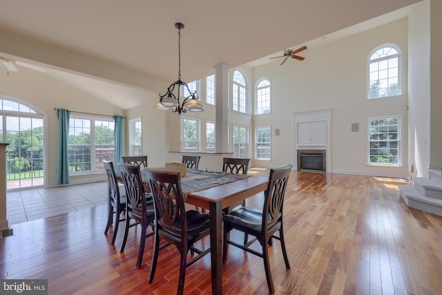 dining area featuring beam ceiling, light hardwood / wood-style flooring, and ceiling fan with notable chandelier