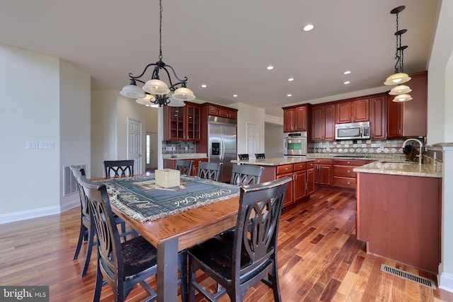 dining room featuring an inviting chandelier, sink, and dark hardwood / wood-style floors