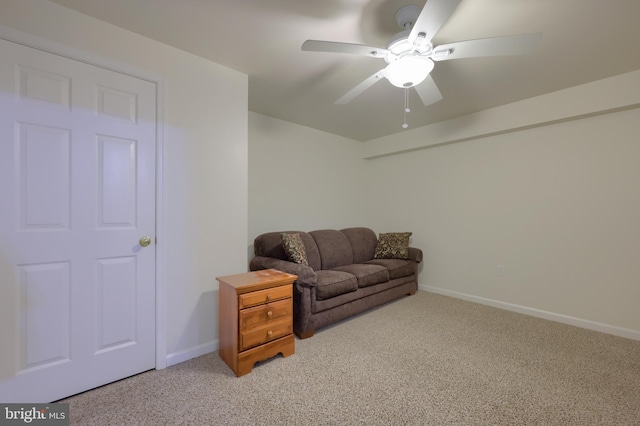 living area featuring light colored carpet and ceiling fan