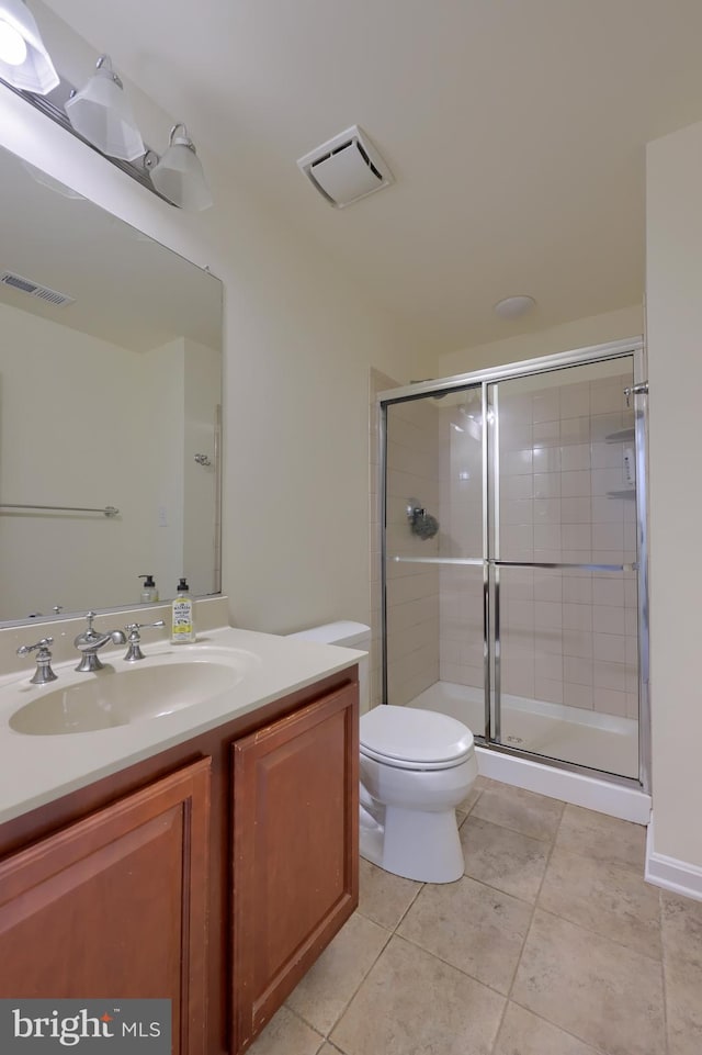 bathroom featuring tile patterned flooring, vanity, an enclosed shower, and toilet