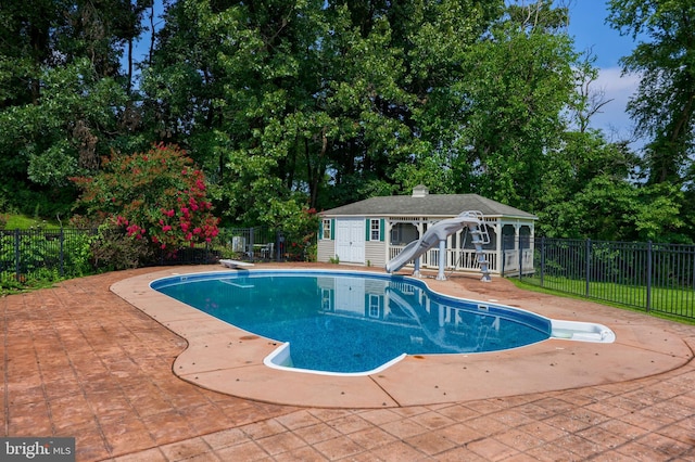 view of pool featuring a patio, an outdoor structure, a diving board, and a water slide