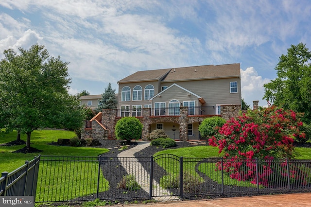 back of property with a balcony and a lawn