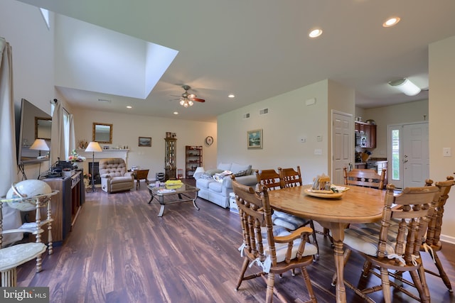 dining space with ceiling fan, dark hardwood / wood-style floors, and a skylight