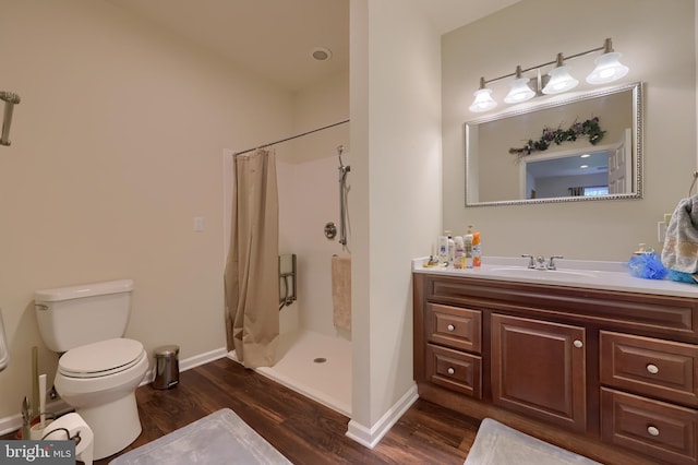 bathroom featuring hardwood / wood-style flooring, vanity, toilet, and curtained shower