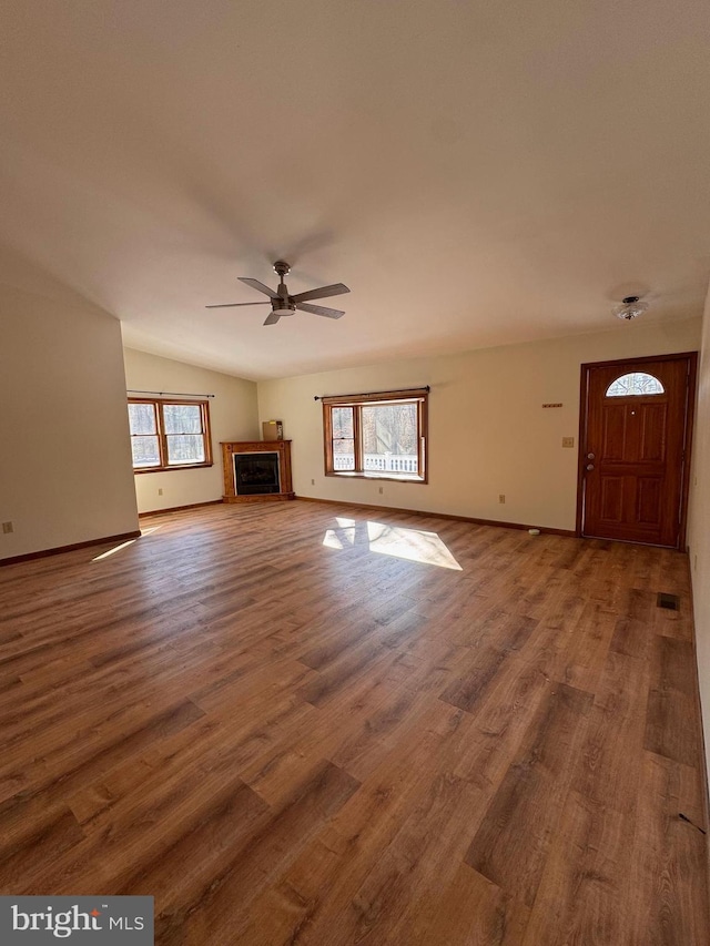 unfurnished living room with hardwood / wood-style flooring, vaulted ceiling, and ceiling fan