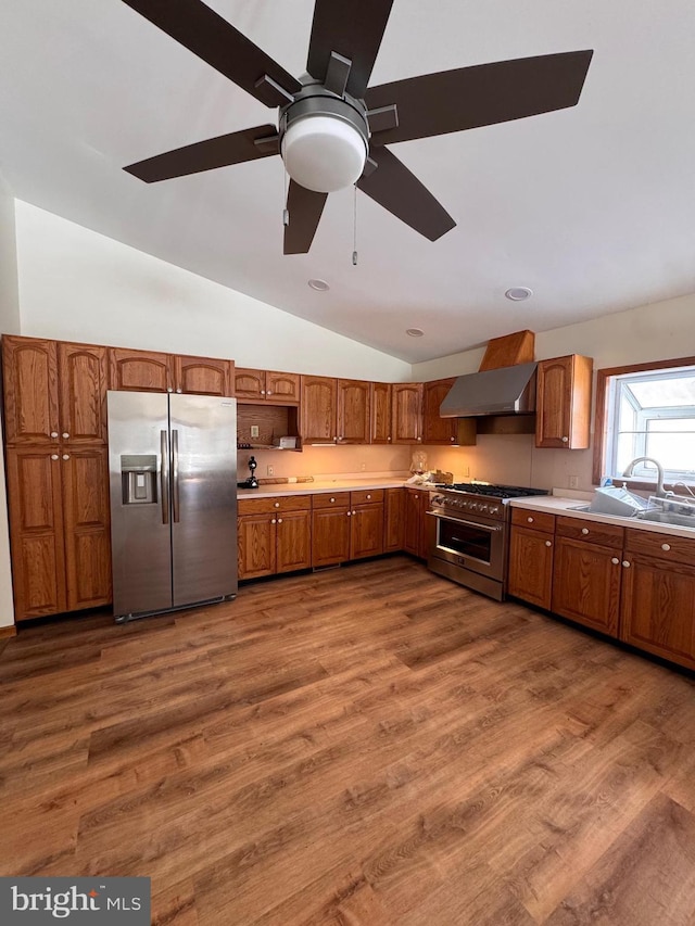 kitchen with dark hardwood / wood-style flooring, wall chimney range hood, sink, and appliances with stainless steel finishes